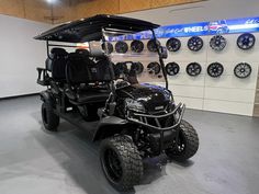 a black golf cart parked in front of a wall with clocks