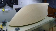 a wooden surfboard being made in a shop