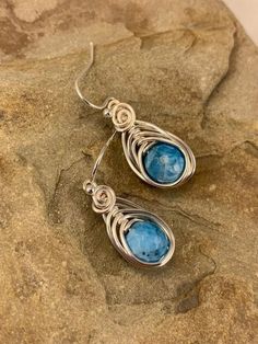 These elegant blue apatite  drop earrings are striking . The micro faceted surface of these genuine apatite  gemstones is beautiful and really catches the eye. They are a gorgeous ocean blue color. I chose to enhance these earrings with a Celtic inspired silver wire design to let the natural beauty of the stone shine. Featuring an 8mm genuine blue apatite gemstone. These earrings are dainty, lightweight  and perfect for everyday wear.  Pair these flattering earrings with your favorite outfit, dr Blue Apatite Gemstone Earrings, Handmade Blue Apatite Earrings, Silver Apatite Dangle Earrings, Blue Apatite Earrings For Gift, Blue Apatite Earrings Gift, Blue Earrings For Gift, Flattering Earrings, Ocean Blue Color, Apatite Jewelry