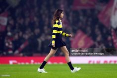 a female soccer player is walking across the field