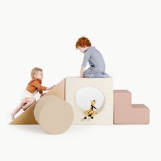 a woman sitting on top of a wooden structure next to a child playing with a toy giraffe