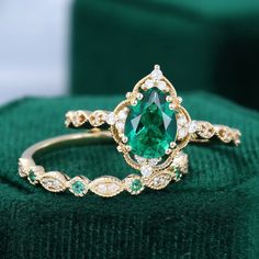 a close up of a ring with a green stone in the middle and white diamonds around it