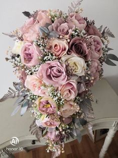 a bridal bouquet with pink roses and baby's breath