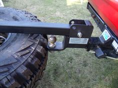 the front end of a red truck with a metal bar on it's side