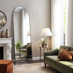 a living room filled with furniture and a fire place under a large mirror on the wall