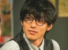 a young man wearing glasses and a vest