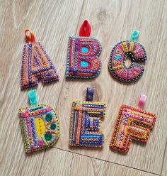 four pieces of colorful beaded fabric sitting on top of a wooden floor next to each other