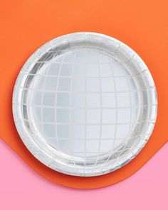 a paper plate on an orange and pink background