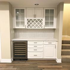 an empty kitchen with white cabinets and drawers