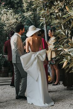 a woman in a white dress standing next to a man