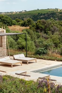 an outdoor swimming pool with lounge chairs next to it