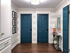 a hallway with two blue doors and pictures on the wall next to eachother