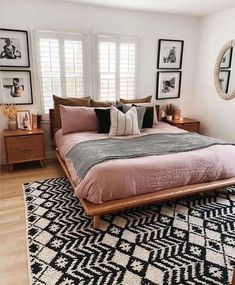 a bedroom with a bed, rug and pictures hanging on the wall above it's headboard