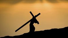 the silhouette of a person carrying a cross on top of a hill with sun behind them