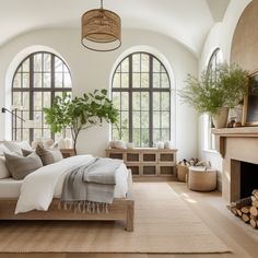 a bedroom with large arched windows and a bed in the middle, surrounded by natural materials