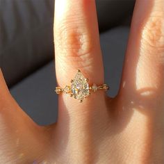 a woman's hand with a yellow diamond ring on top of her finger,