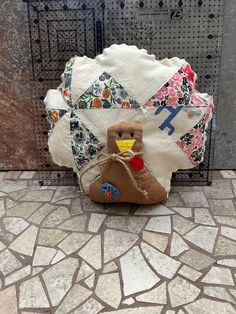 a stuffed turkey sitting on top of a tile floor next to a bag with a bird on it