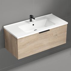 a white sink sitting on top of a wooden cabinet next to a wall mounted faucet