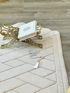 a white table topped with a book on top of a wooden floor next to a pair of scissors