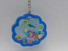 a keychain with an image of fish in the ocean on it's side