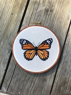 an orange and black butterfly sitting on top of a wooden table