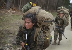 the soldiers are carrying their belongings down the path