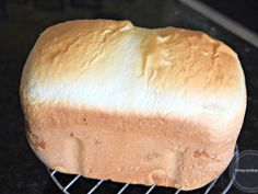 a loaf of bread sitting on top of a metal rack next to a black counter