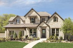 a large brick house with lots of windows and landscaping around the front door is shown