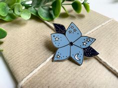 Brighten up your jacket, tote bag or lanyard with this pretty blue Moonflower enamel pin badge!  This hard enamel pin features a pale blue five-petaled flower with intricate moon and star details, and navy blue leaves. - Durable hard enamel  - High polish silver  - 35mm across at the widest point (leaf to leaf!)  - Rubber clutch Blue Enamel Brooch Gift, Blue Enamel Brooch For Gift, Blue Enamel Brooches For Gift, Blue Enamel Pin For Gift, Blue Enamel Pins For Gifts, Blue Brooch Pin For Gift, Blue Brooch Pins For Gift, Blue Brooch Pin As Gift, Blue Brooch Pins As A Gift