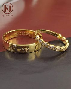 two gold wedding rings sitting on top of a table