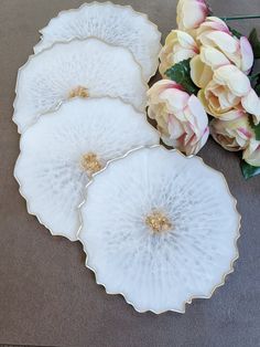 three white plates with gold rims and flowers