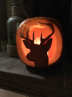 a carved pumpkin with a deer's head in the center and antlers on it