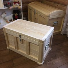 two wooden chests sitting on top of a hard wood floor next to a shelf with stuffed animals