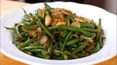 a white bowl filled with green beans and onions