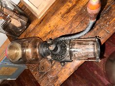 an old fashioned lamp sitting on top of a wooden table next to a glass bottle