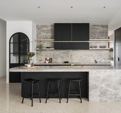 a kitchen with marble counter tops and black cabinets, along with two bar stools