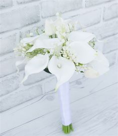 a bouquet of white flowers in front of a brick wall