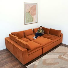 a woman sitting on top of an orange couch