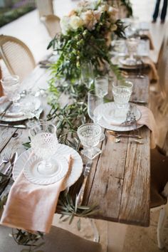 the table is set with white plates and silverware