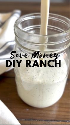 a mason jar filled with homemade diy ranch dressing on top of a wooden table