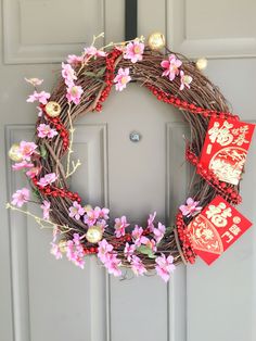 a wreath with red and pink flowers on the front door