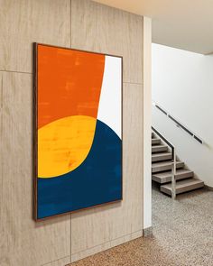 an abstract painting hangs on the wall next to a stair case in a modern building