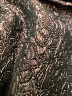 closeup of an intricately detailed design on a dress fabric, showing the details of lace and sequins