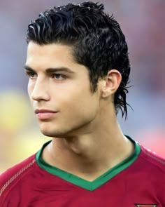 a young man with black hair wearing a red shirt and green trim on his head