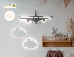 an airplane is hanging on the wall next to a shelf with clothes and stuffed animals