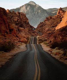 an empty road in the middle of some mountains