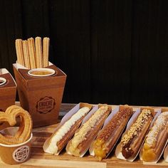 hot dogs and pretzels on a table next to some snacks, with drinks