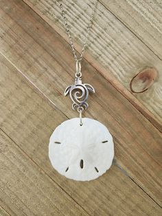 "Show off your love of the beach and marine animals with this statement necklace. The genuine, natural sand dollar is approximately 2\" across and is hanging from an adorable sea turtle silver charm.  The sand dollar is real and is in its natural state. . It is set on an 18\", anti-tarnish stainless steel silver chain that sparkles in the light. Multiple sizes of chain are available. , with the same style chain. This pendant makes a lovely gift for yourself or that beach/ sea turtle lover in you Sand Dollar Necklace, Sand Dollar Pendant, Sea Turtle Necklace, Beach Necklace, Silver Sea, Beach Necklaces, Turtle Charm, Turtle Necklace, Seashell Crafts