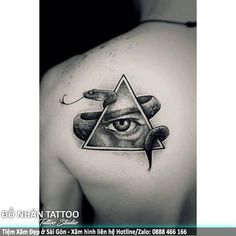 an all seeing tattoo on the back of a man's shoulder