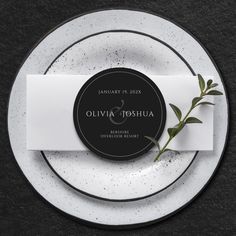 a plate with a place card on it next to a silver and black charger